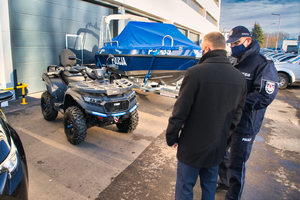 Mężczyzna i policjant oglądają zaparkowanego quada