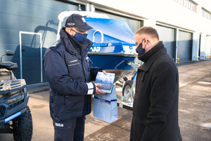 policjant przekazuje mężczyźnie książkę