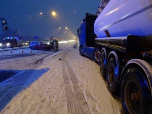 widok na rozbity samochód osobowy i ciężarowy stojący na drodze