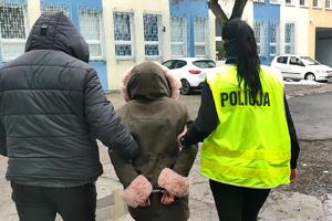 Policjant i policjantka prowadzą zatrzymaną kobietę