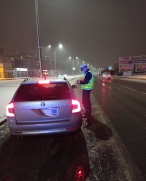 Policjant kontroluje zatrzymany do kontroli samochód