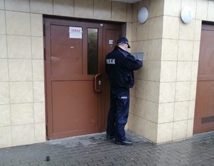 Policjant rozmawia przez domofon