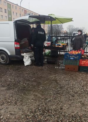 Policjant podczas kontroli przy samochodzie.