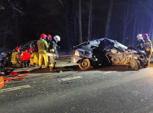 Widok na rozbite dwa samochody i służby ratownicze