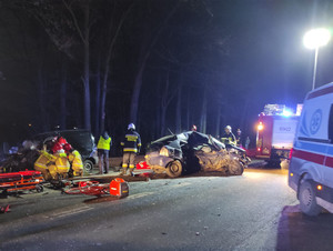 Widok na rozbite dwa samochody i służby ratownicze