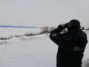 Policjant kontroluje zamarznięty akwen