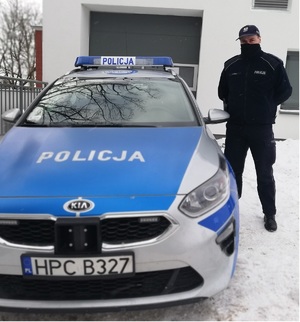 Policjant przy radiowozie.