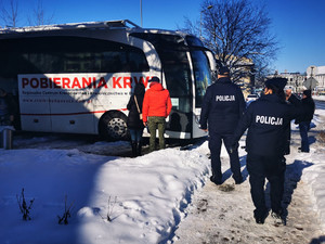 Dwóch policjantów stoi przed autobusem