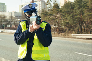 Policjant dokonuje pomiaru prędkości na drodze