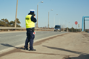 Policjant dokonuje pomiaru prędkości na drodze