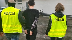 Policjanci prowadzą zatrzymanego