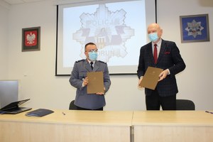 Komendant Miejski Policji w Toruniu i Prezydent Miasta Torunia pokazują dokument