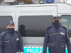 Policjanci na tle radiowozu.