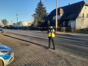 Policjant mierzy prędkość nadjeżdżającego auta