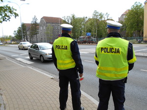 Dwóch policjantów stoi przy drodze