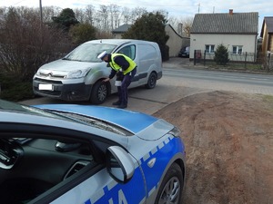 Policjant sprawdza ogumienie samochodu osobowego