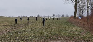 Rząd policjantów i strażaków stoi na polu gotowi do poszukiwań