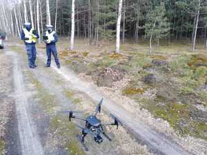 Policjanci ruchu drogowego i latający przed nimi dron