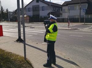 policjantka mierzy prędkość przy drodze