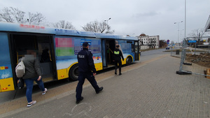 Policjant i strażniczka miejska wchodzą do autobusu