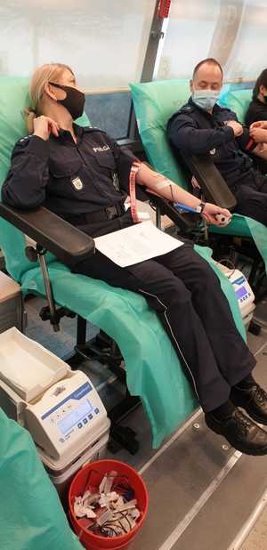 policjantka i policjant siedzą na fotelu i oddają krew