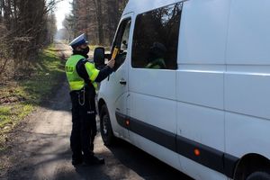 Policjanci kontrolują zatrzymany samochód