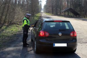 Policjanci kontrolują zatrzymany samochód