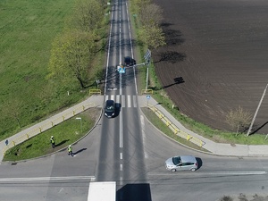 widok na skrzyżowania, na którym policjanci prowadzą kontrolę ruchu drogowego. Widać przejeżdżające pojazdy.