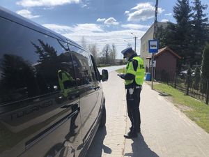 Policjant kontroluje zatrzymany samochód