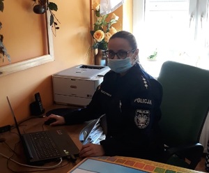 Policjantka siedzi przy laptopie