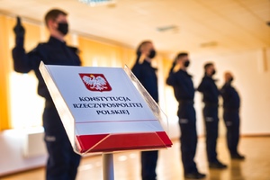 widok na konstytucję i składających ślubowanie policjantów