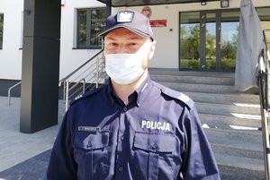 Policjant przed budynkiem.