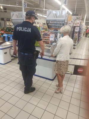 policjant rozmawia z kobietą w sklepie