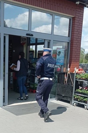 Policjant wchodzi do galerii, by skontrolować przestrzeganie obostrzeń