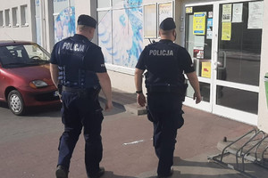 Policjanci idą do sklepu, by przeprowadzić kontrole przestrzegania obostrzeń