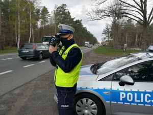 Policjant RD trzyma miernik i patrzy przez niego