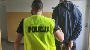 Policjant prowadzi zatrzymanego