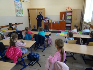 Policjantka stoi przy tablicy w klasie i rozmawia z dziećmi