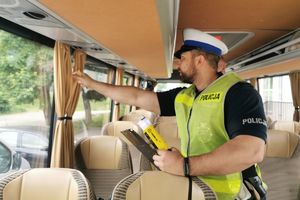 Policjant kontroluje wyjście awaryjne autobusu