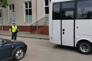 Policjant stoi za autobusem