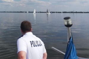 Policjanci obserwują łodzie biorące udział w regatach