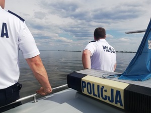 Policjanci obserwują łodzie biorące udział w regatach