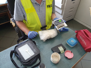 Policjant pokazuje zabezpieczony kg amfetaminy