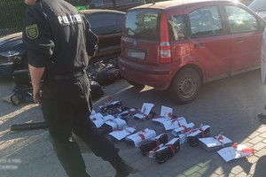 niemiecki policjant przechodzi obok części samochodowych z dokumentacją