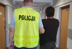 Policjant prowadzi zatrzymanego &quot;bombiarza&quot;