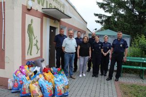 policjanci i pracownicy schroniska dla zwierząt pozują do zdjęcia