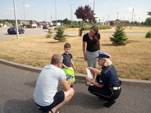 Policjantka przekazuje dziecku odblaski