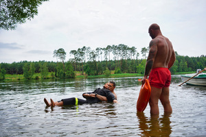 Mężczyzna trzyma manekina, który unosi się na wodzie
