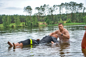 Mężczyzna trzyma manekina który unosi się na wodzie