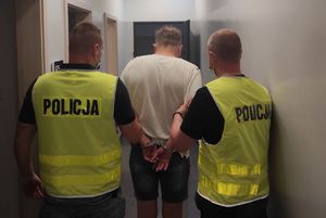 Policjanci prowadzą zatrzymanego łapówkarza